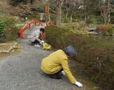 庭園内の池に架かる必度橋手前の清掃風景