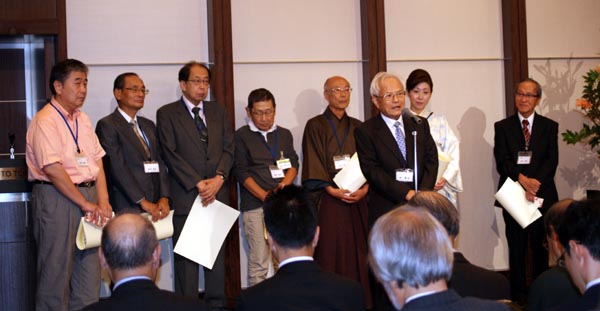 感謝状贈呈後に挨拶する林寛治監事(右から3人目)、後列右から犬飼利和会員、田村光弘専務理事、高橋克仁理事、櫻井英成会員、木村哲夫会員、湯村正子会員、坂本孝志特別顧問